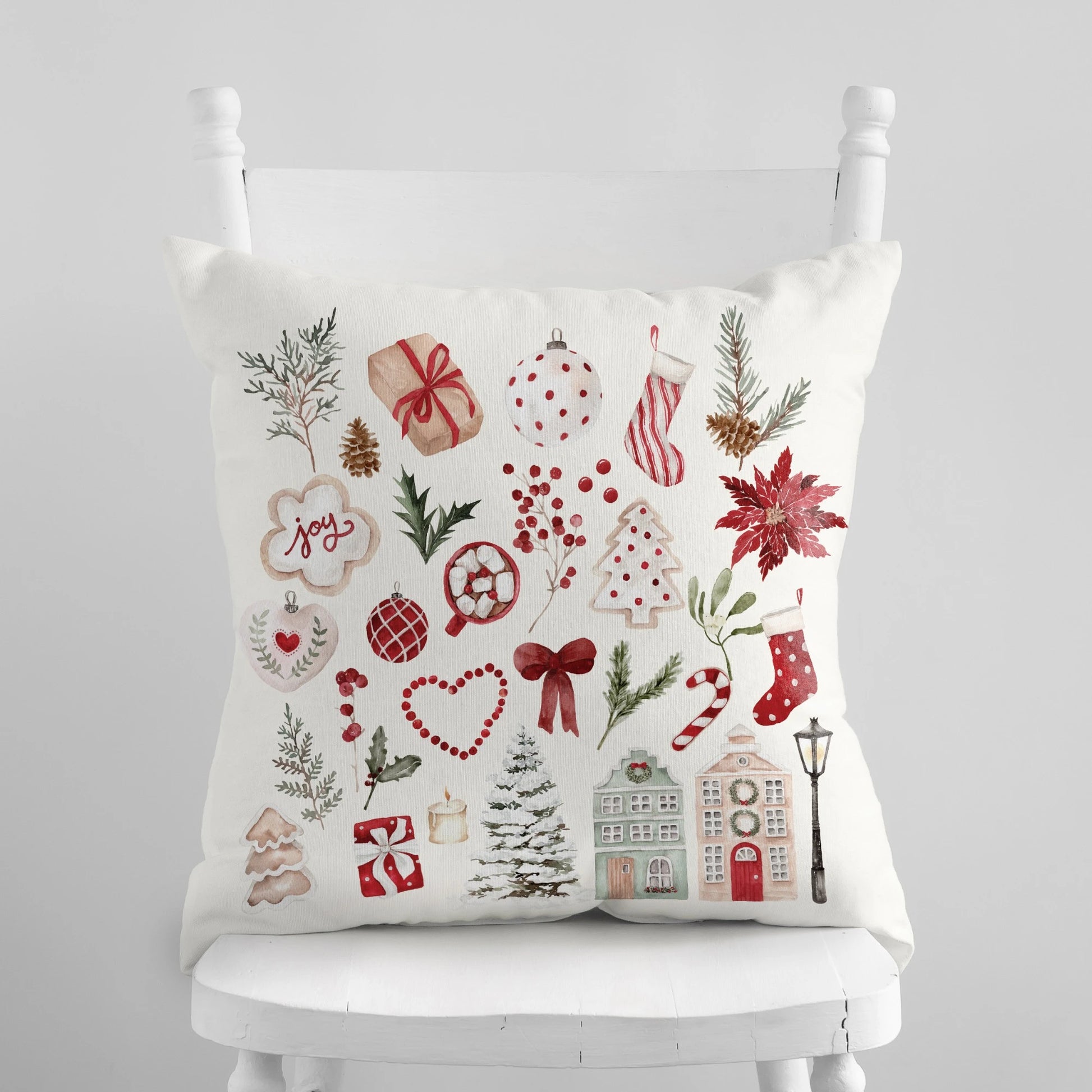 Watercolor Christmas pillow cover with red and green holiday motifs – poinsettia, pine, gifts, and ornaments.