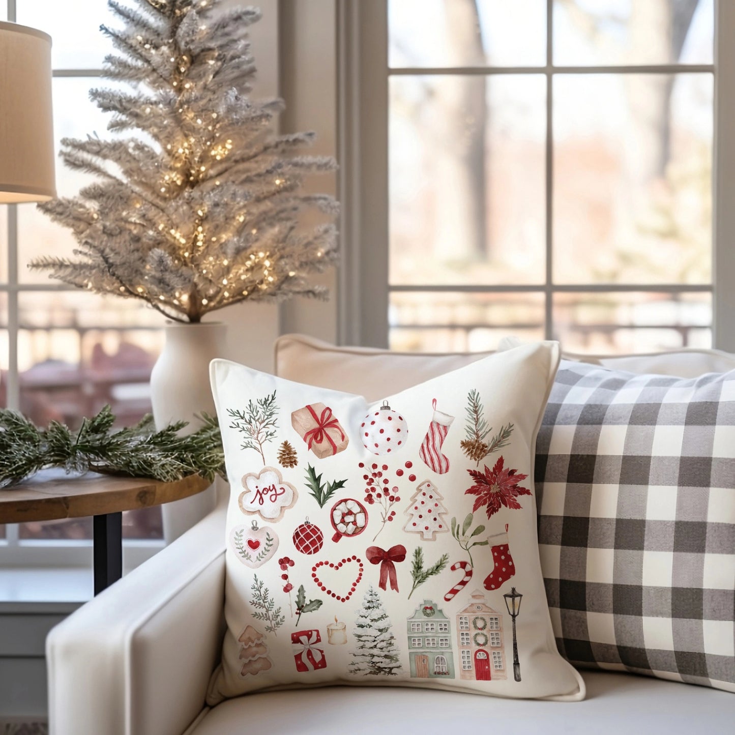 Watercolor Christmas pillow cover on white armchair – festive red and green holiday design in Scandinavian-inspired living room.