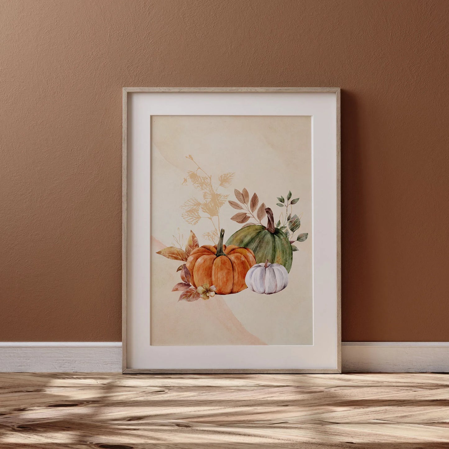 Watercolor Fall Pumpkin poster from Blue Water Songs in wood frame leaning against brown wall