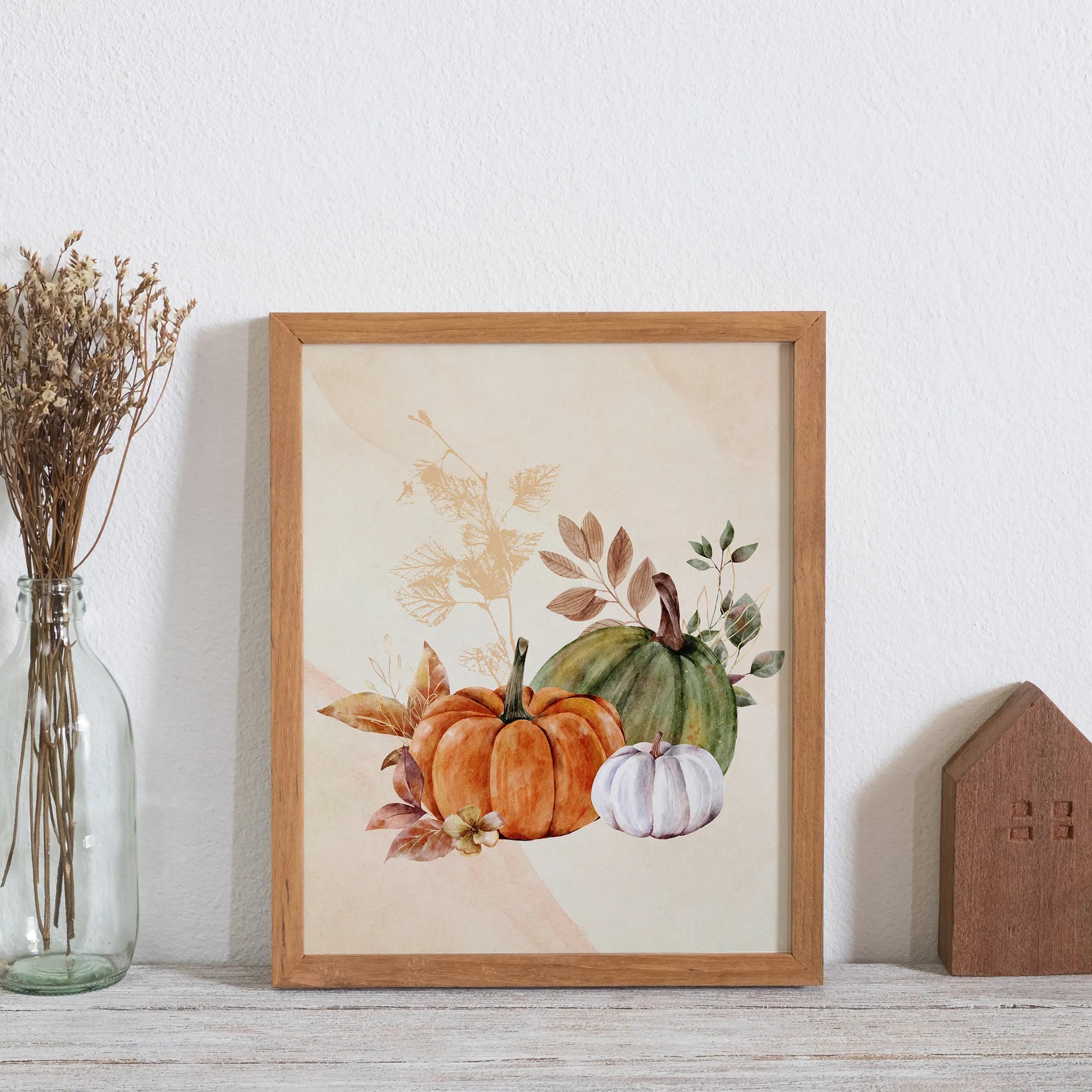 Watercolor Fall Pumpkin art from Blue Water Songs place next to dry flower bottle 