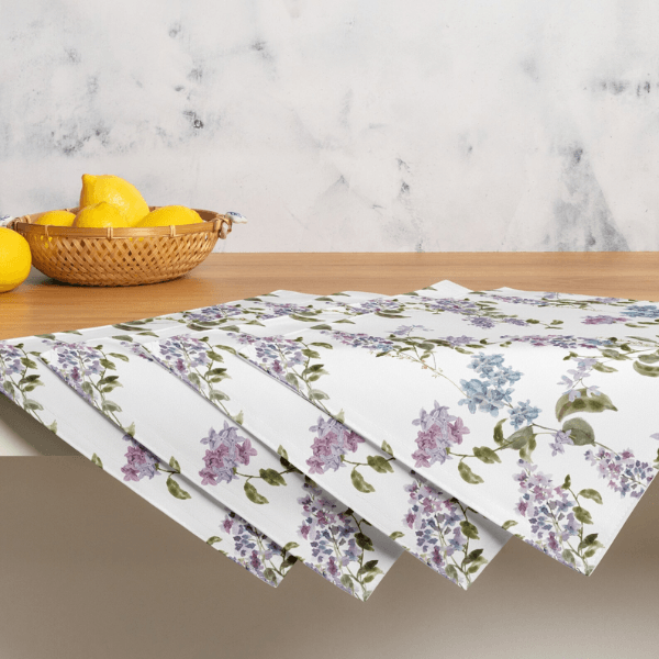 Watercolor Lilac Flower PLACEMAT Set displayed on a wooden table with a basket of lemons in the background.