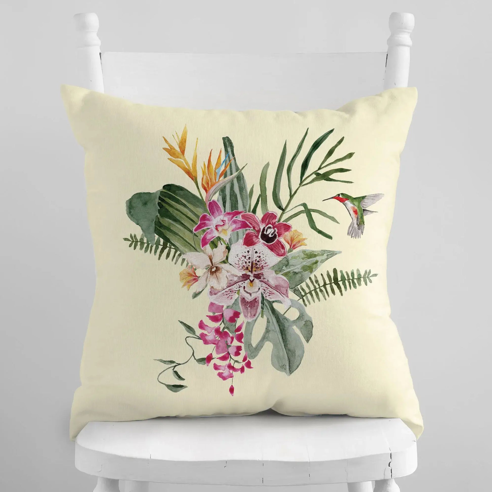 Watercolor Orchid & Hummingbird Pillow showcasing vibrant flowers and tropical leaves on a cream background.