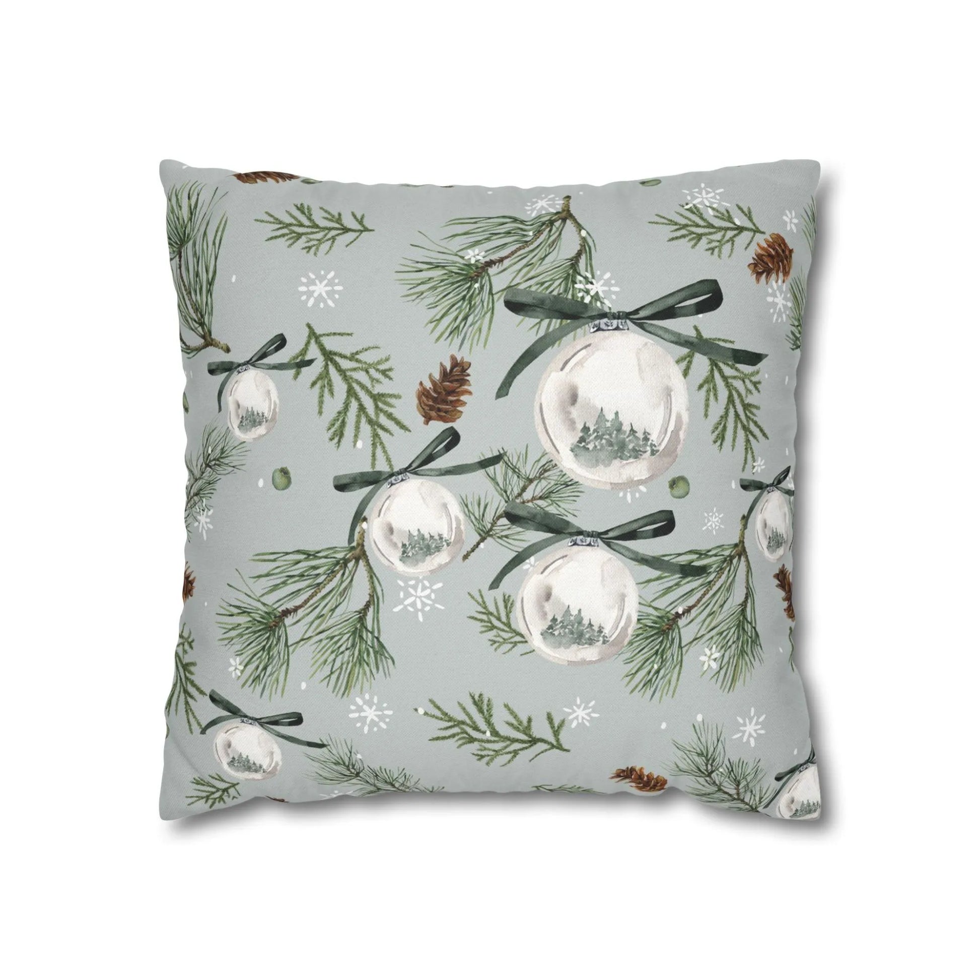 Watercolor pine Christmas ornament pillow with green branches and snowflakes on soft gray background