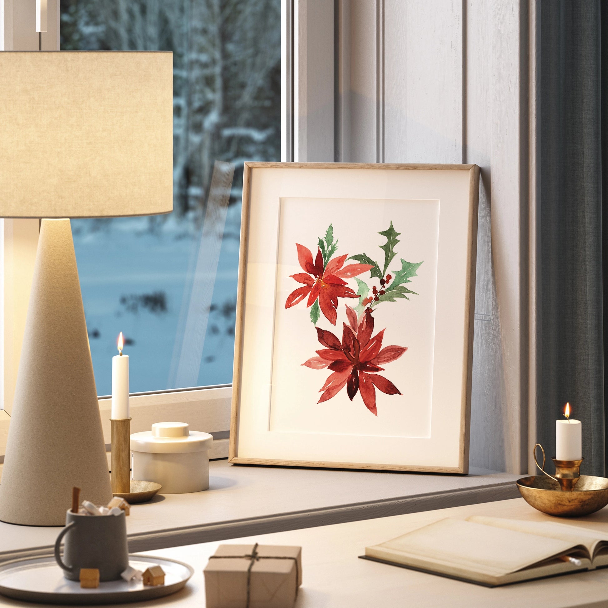 Poinsettia Christmas Art print displayed in a cozy winter scene with a lamp and candles.