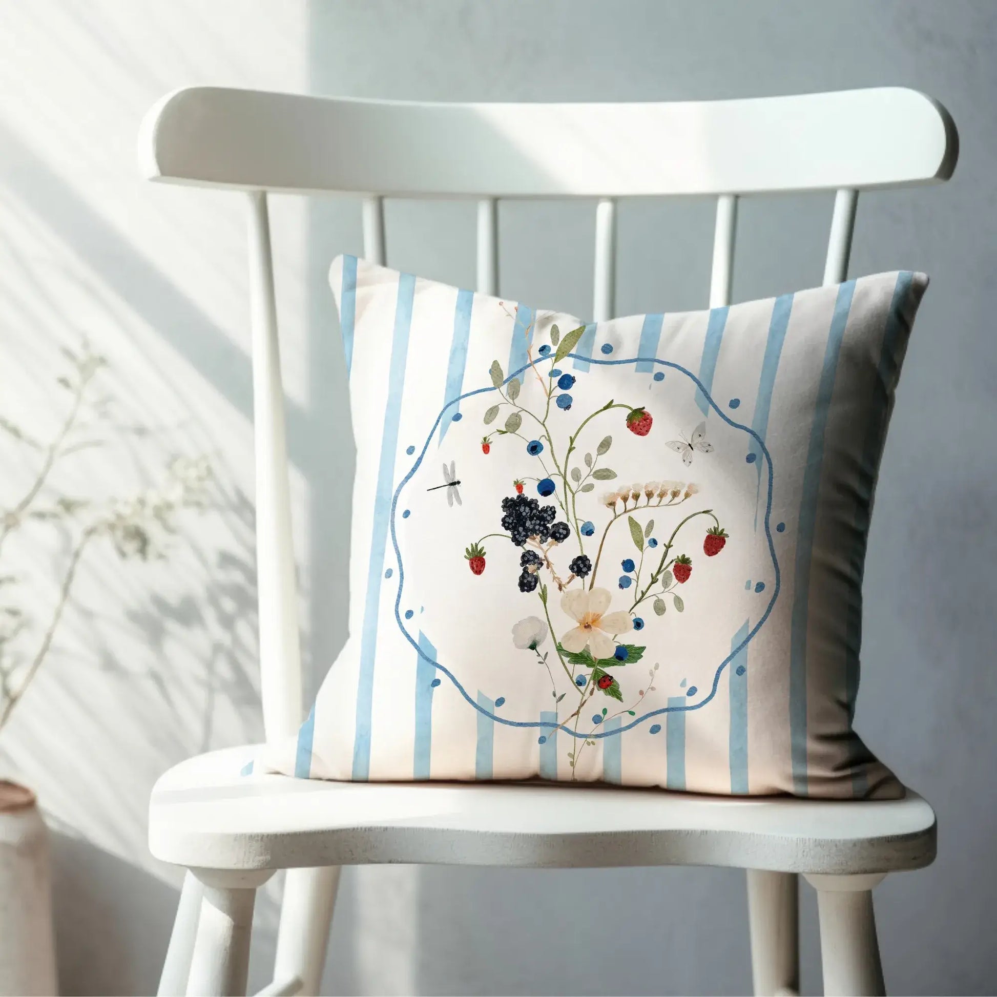 Watercolor Wildflower and Berry Pillow and Cover on a white chair with blue stripes and floral design.