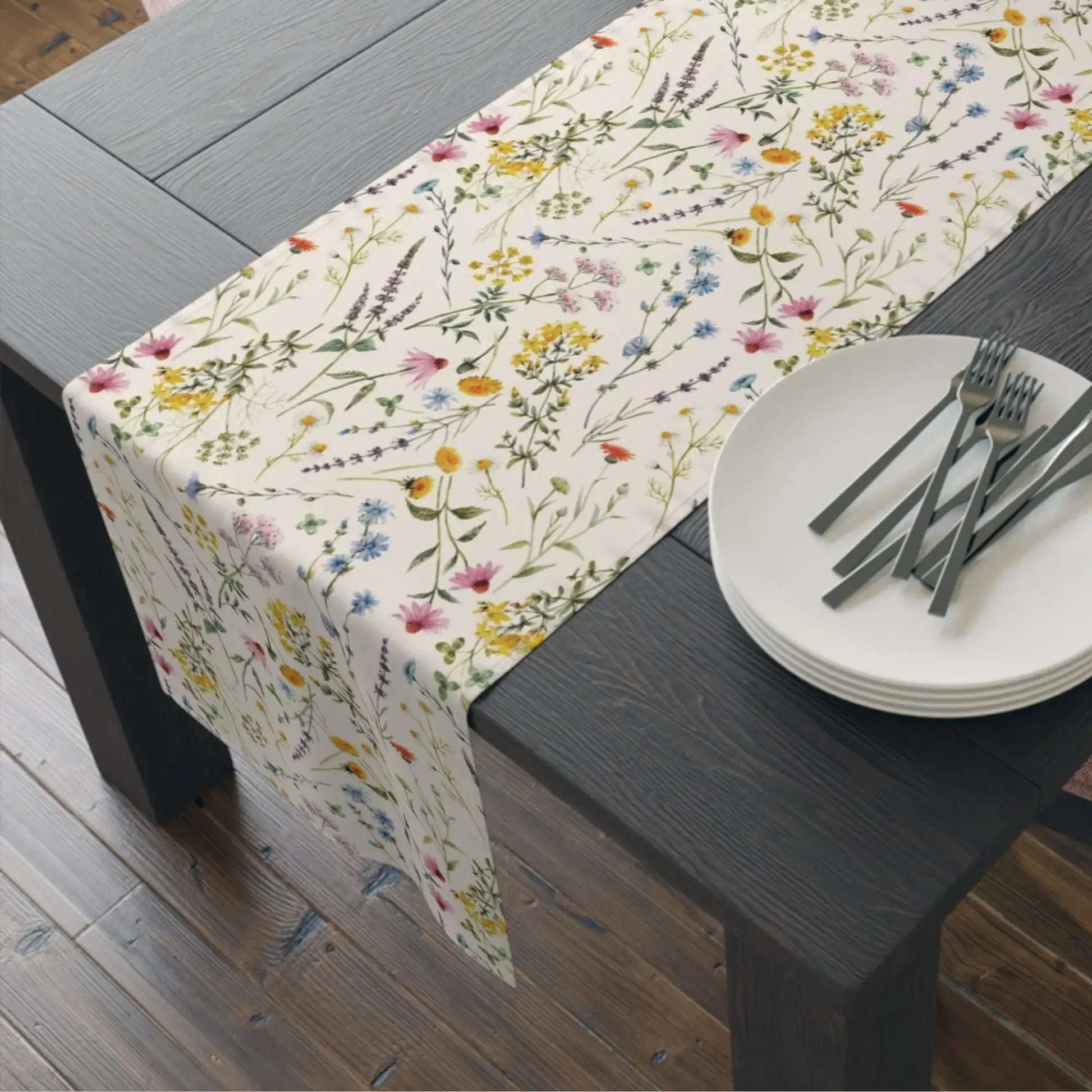 Watercolor Wildflowers Table Runner elegantly draping over a wooden dining table, surrounded by plates and cutlery.