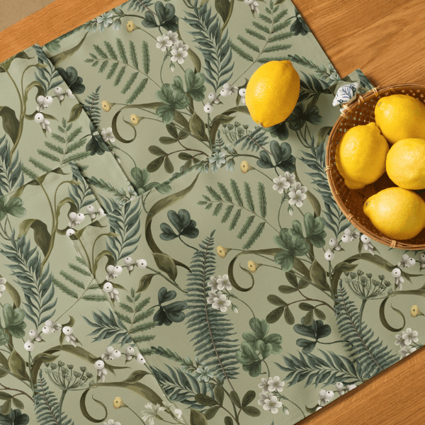 wood table with 4 green placemats on it next to lemons