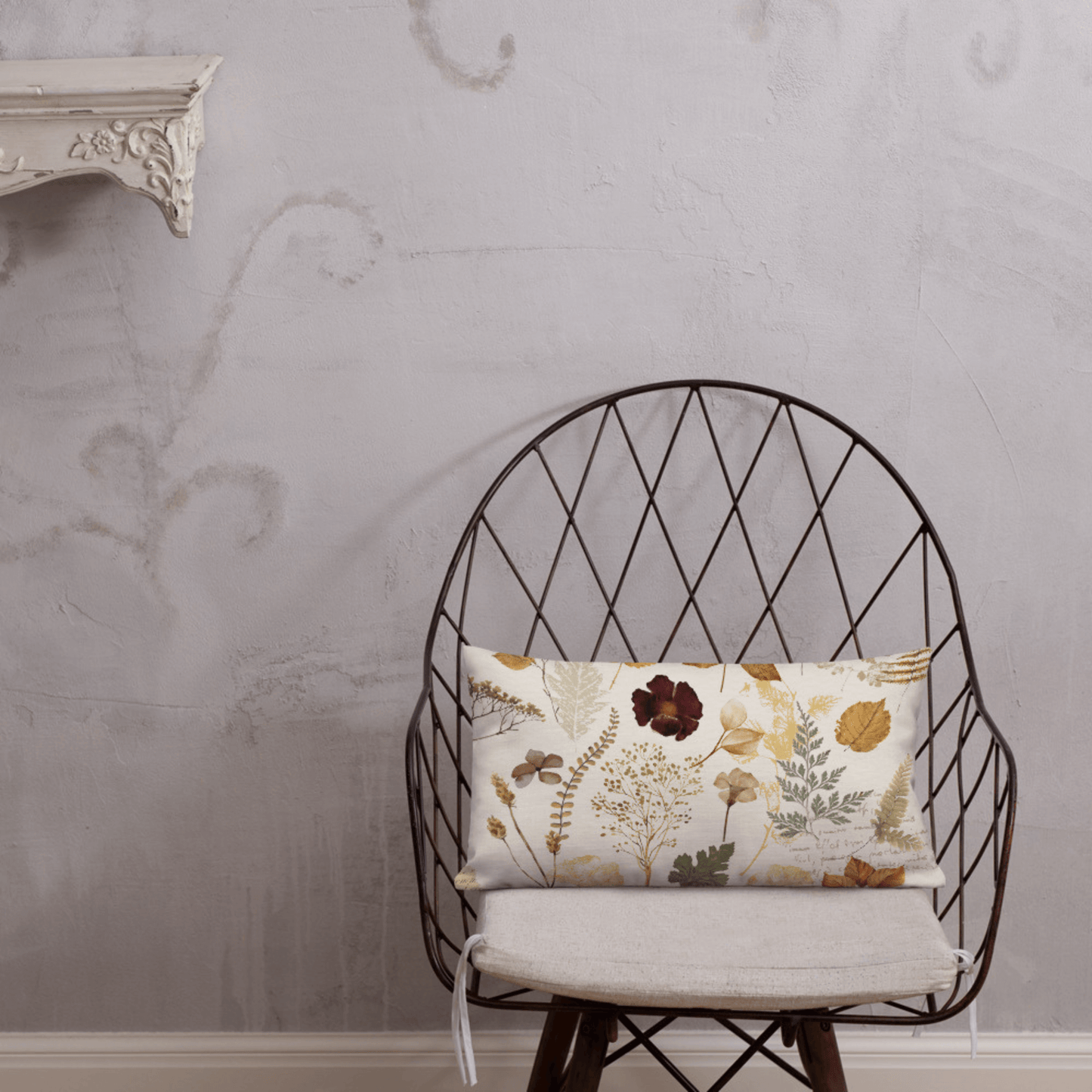 Wildflower autumn PILLOW on a stylish chair, featuring pressed leaves and dried flowers in botanical design.