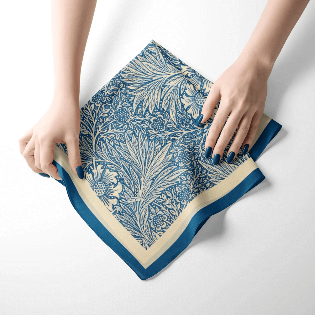 William Morris silk scarf blue floral displayed with hands showcasing the Marigold pattern's intricate design.