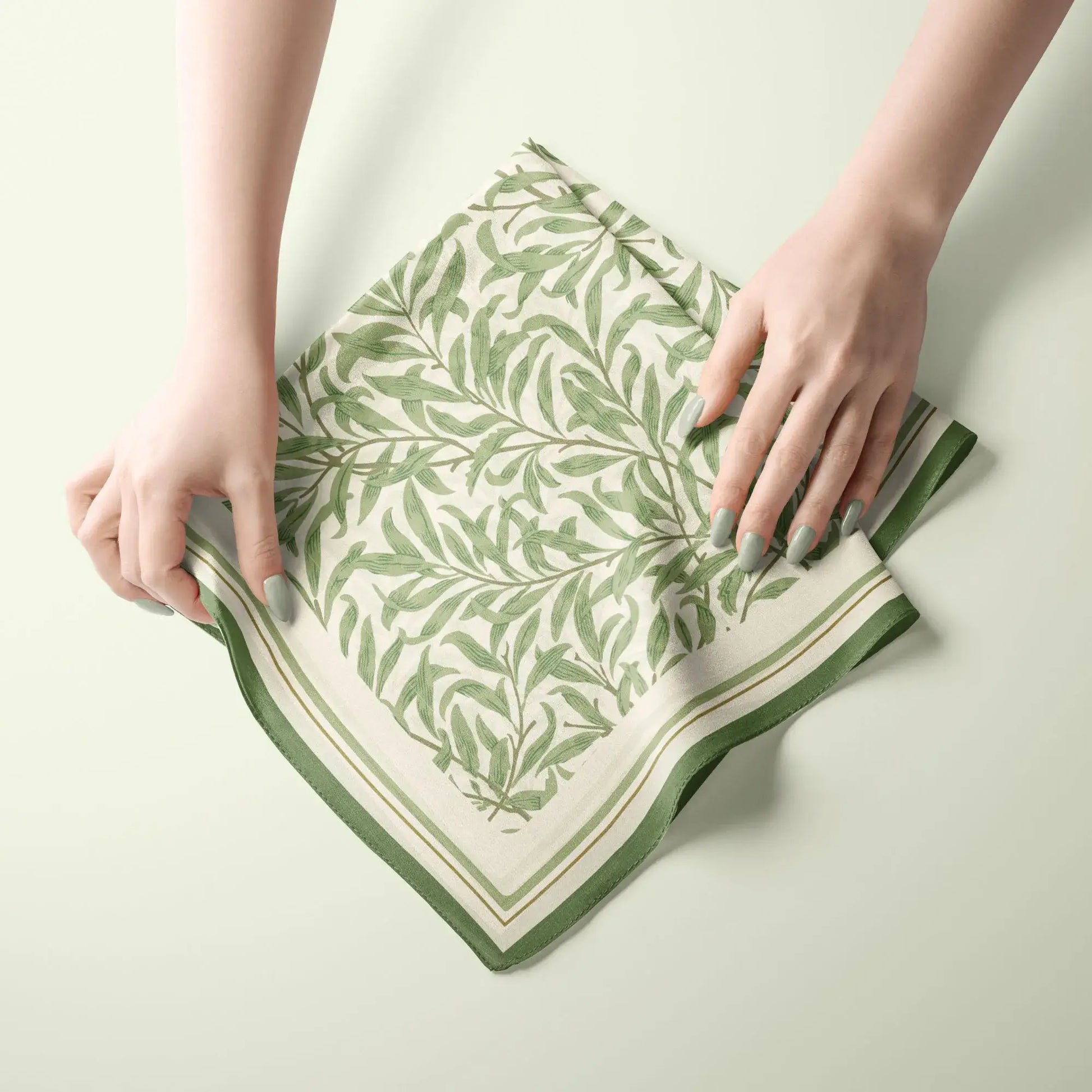 William Morris Silk Scarf Green Willow Boughs displayed with hands, showcasing elegant leaf patterns and vintage charm.