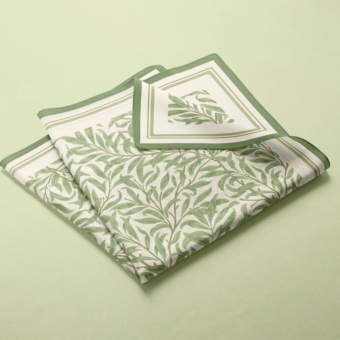 William Morris Silk Scarf Green Willow Boughs neatly folded on a soft green background.