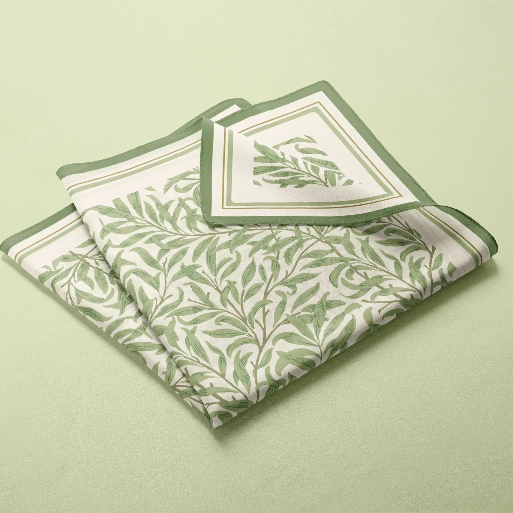 William Morris Silk Scarf Green Willow Boughs neatly folded on a soft green background.