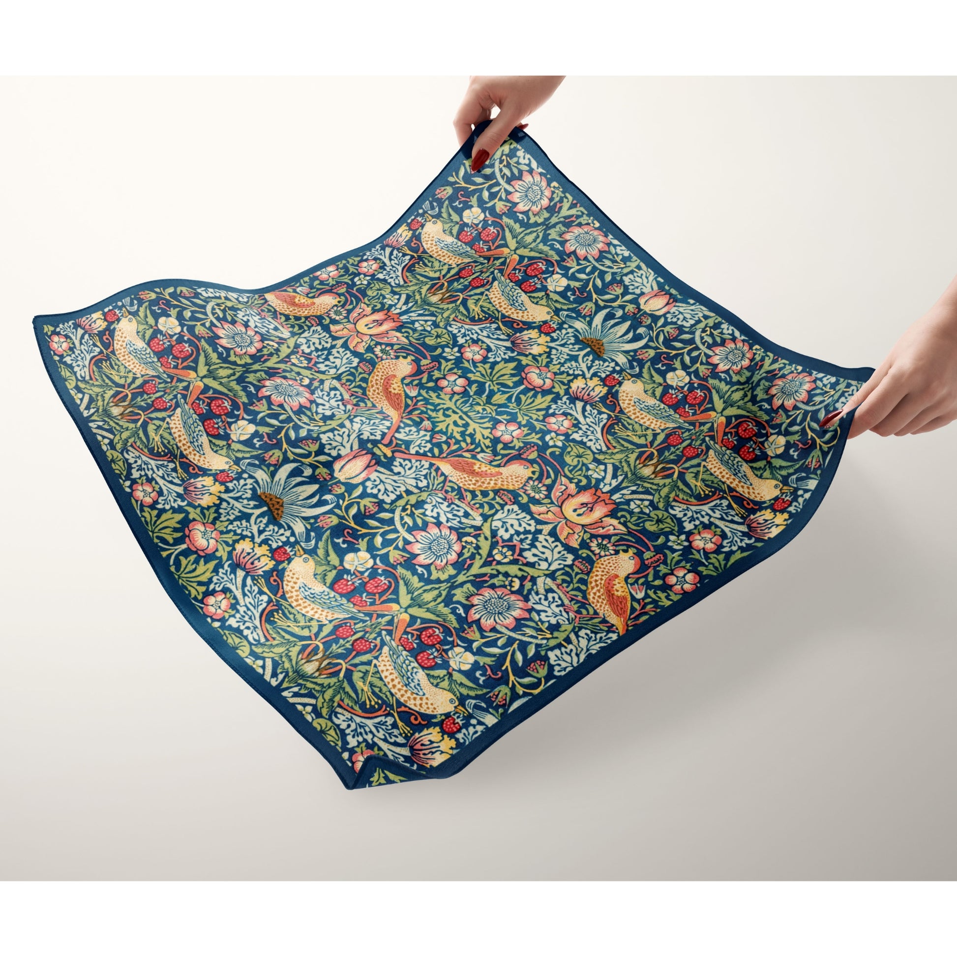William Morris Strawberry Thief Silk Scarf displayed, showcasing intricate floral and bird designs on a blue background.