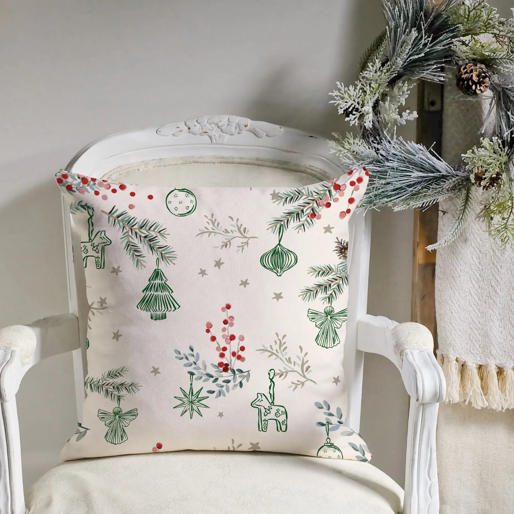 Winter berry Christmas pillow cover with green and red holiday designs on a cream background.