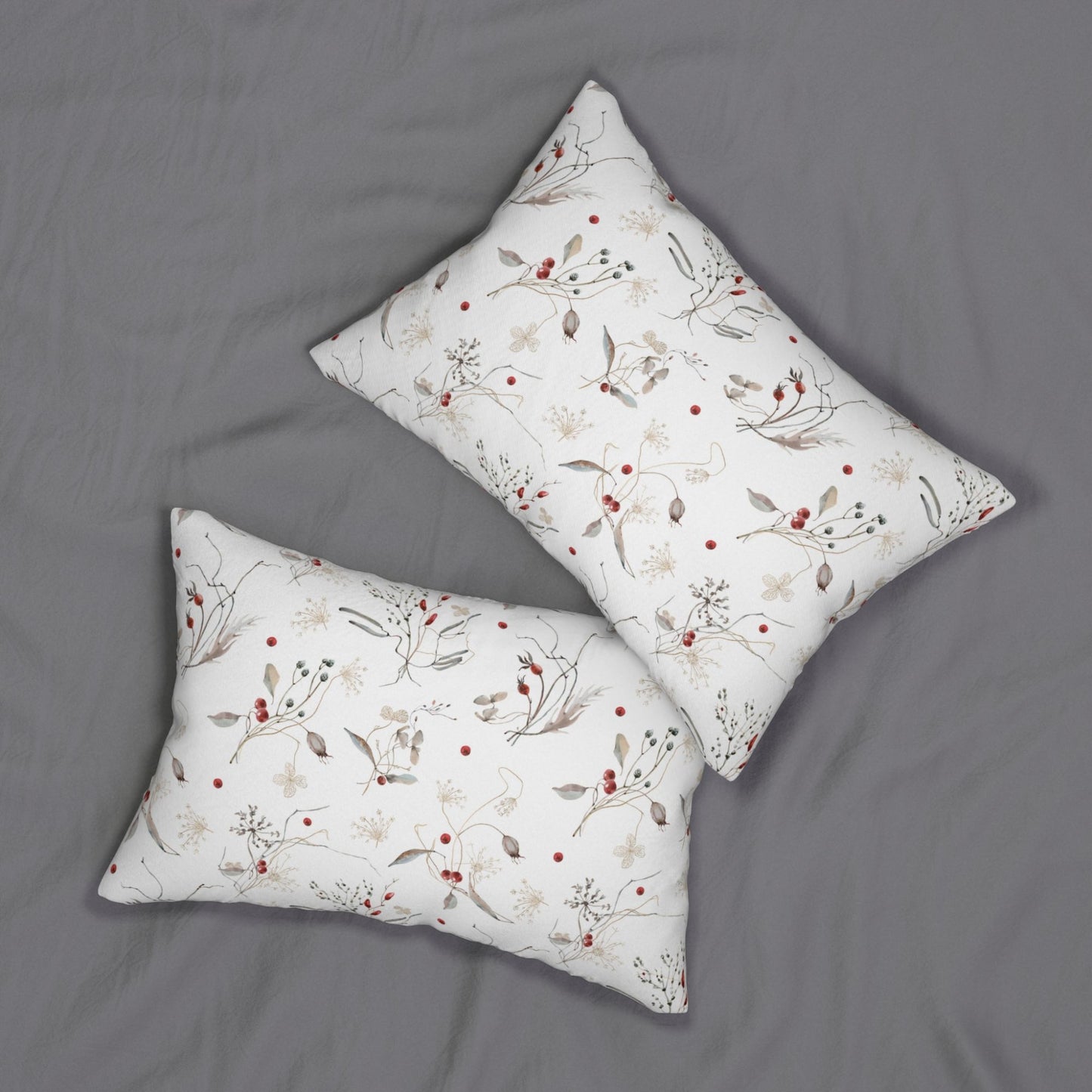 Set of two winter botanical lumbar pillows with red berry design on gray bedding