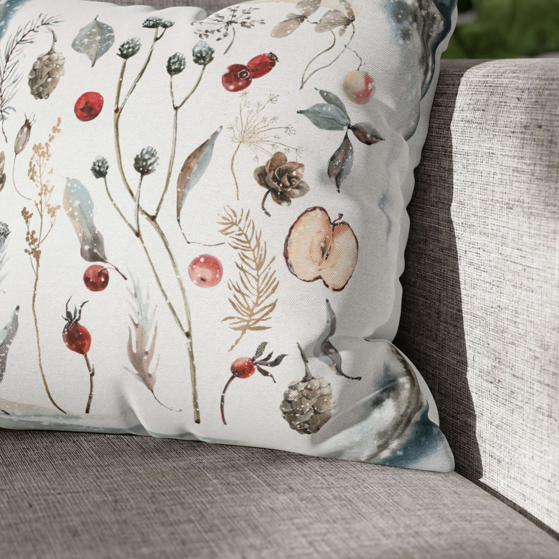 Winter Botanical Pillow Cover featuring watercolor pinecones, berries, and dried greenery on a cozy sofa.