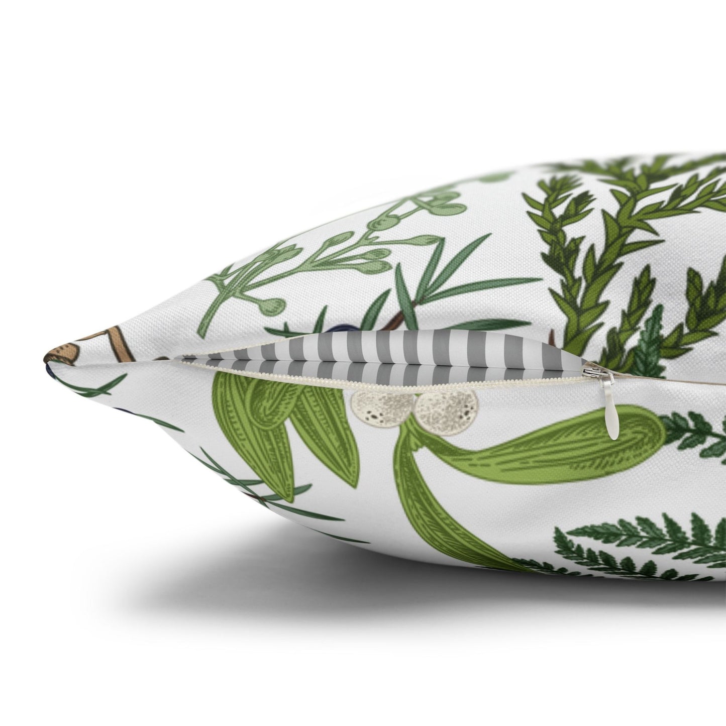 Side view of winter botanical pillow with green fern and mistletoe, showing hidden zipper closure