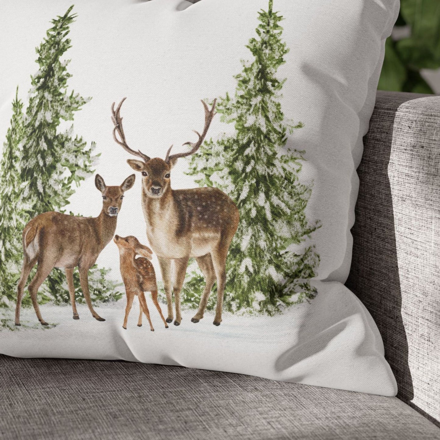 Close-up of deer and pine tree Christmas pillow on gray couch – cozy winter decor