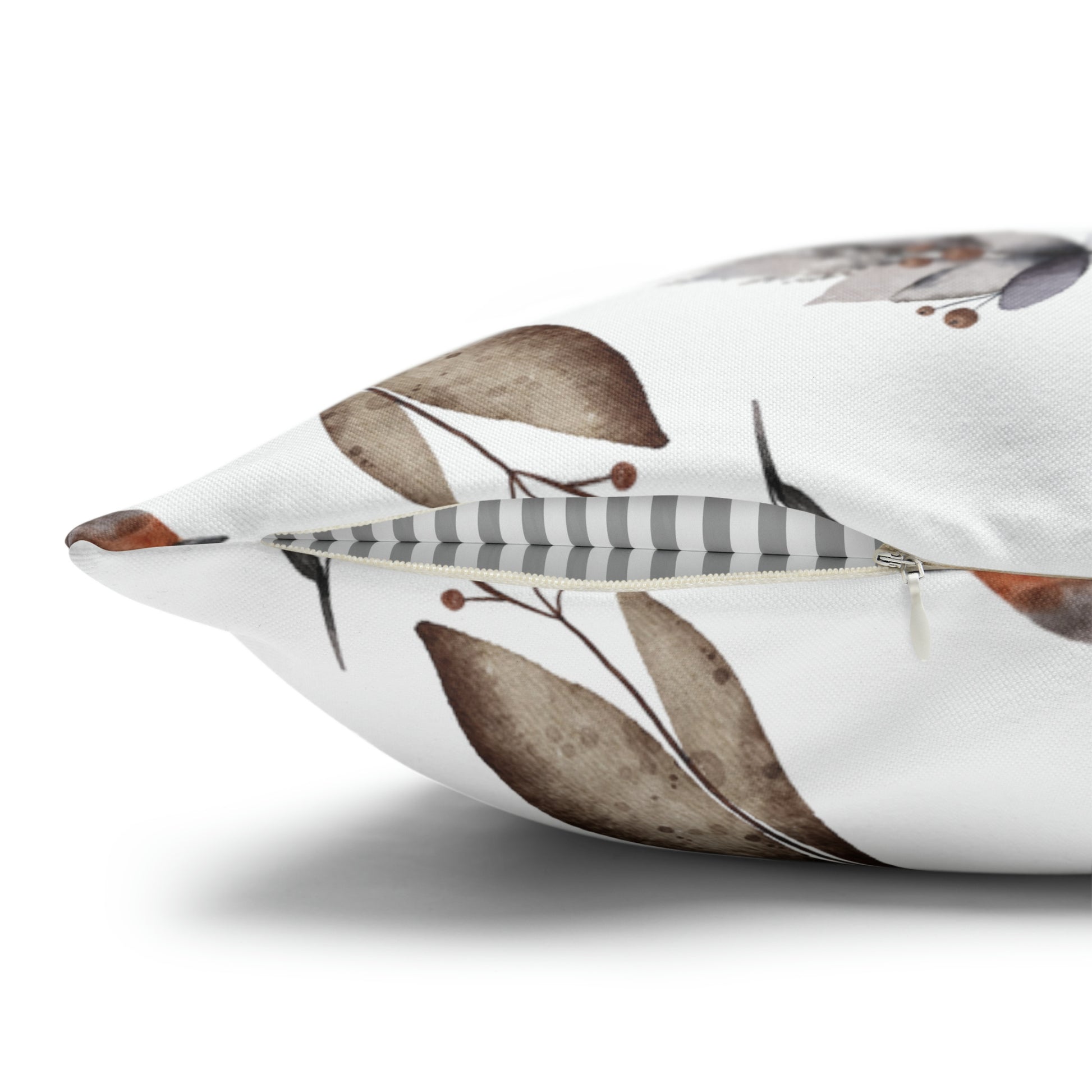 Close-up of winter botanical pillow with brown watercolor leaves and hidden zipper detail