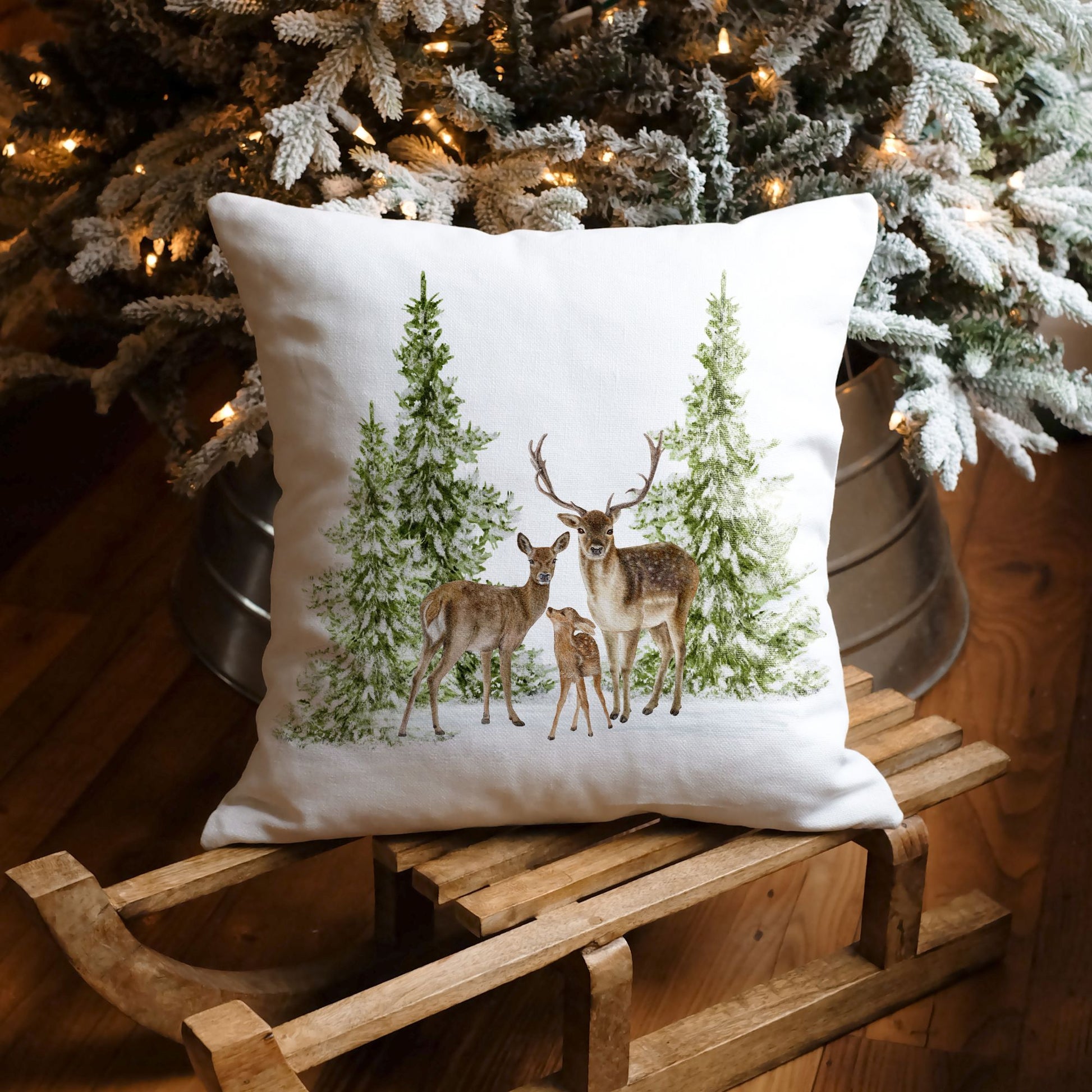 Christmas pillow with deer family and pine trees on sled under holiday tree – cozy winter decor