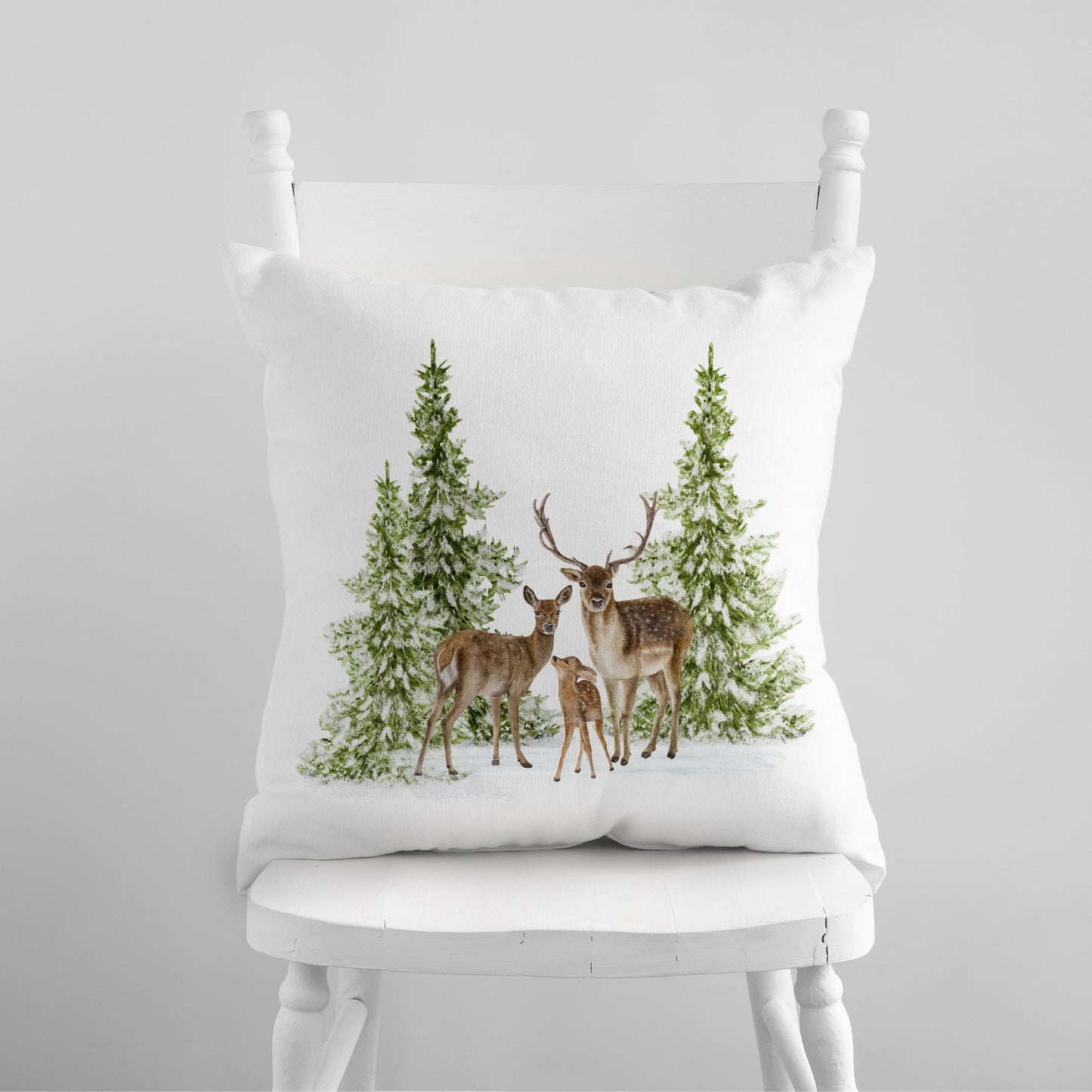 White pillow with watercolor deer family and pine trees – nature-inspired Christmas decor