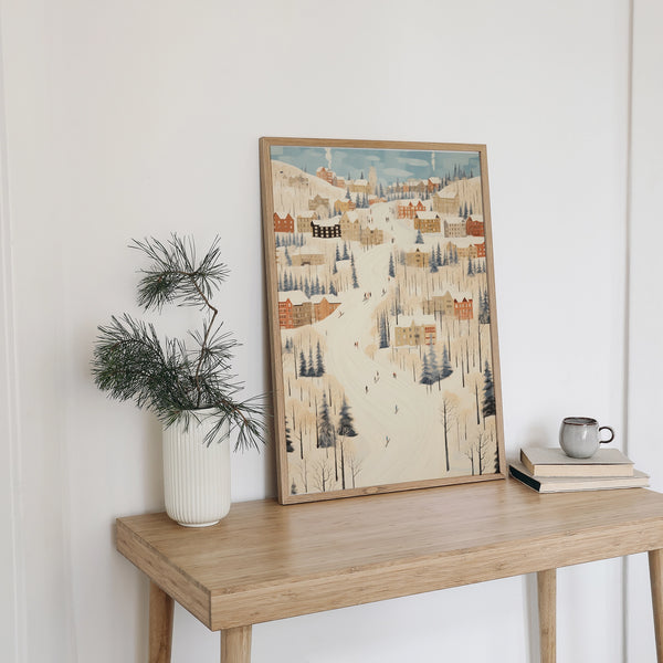 cute eclectic winter village poster placing next to white vase and green pine branch