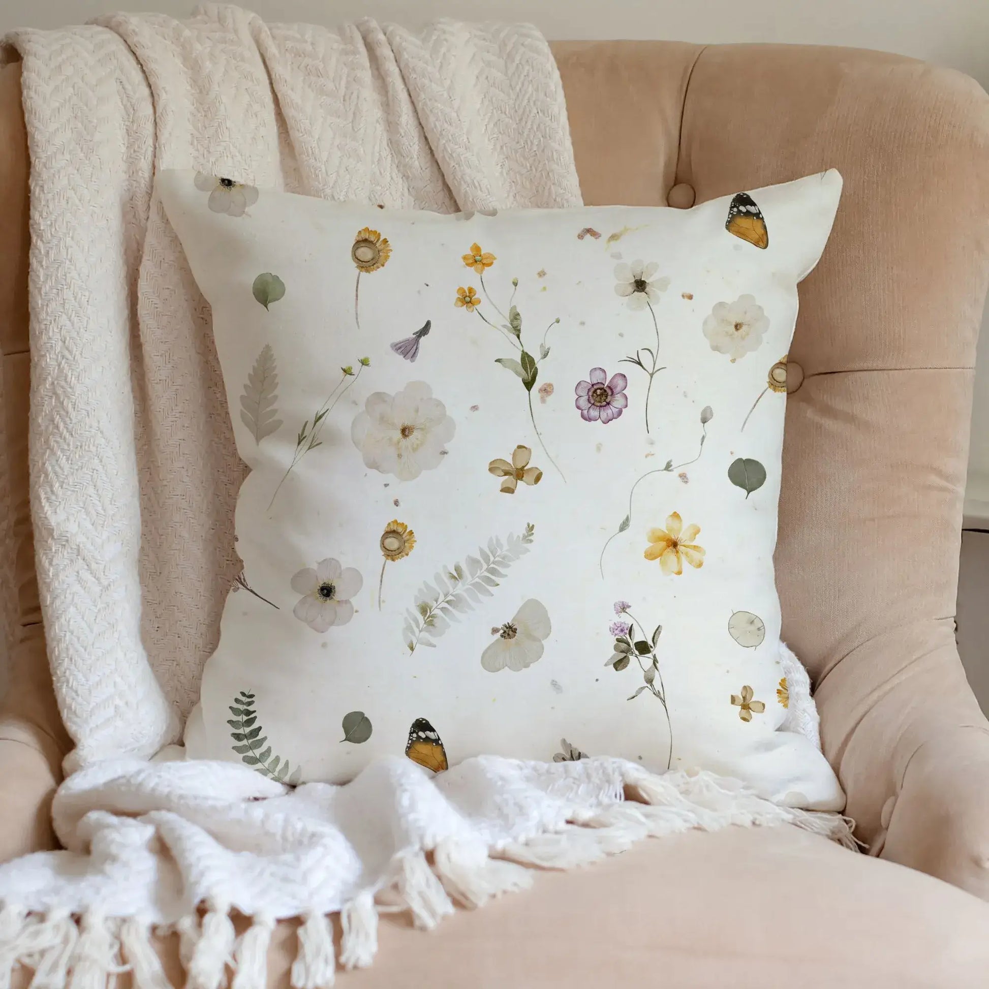 Yellow Watercolor Pressed Flowers PILLOW on a cozy chair with soft textures and botanical designs.
