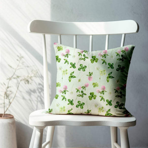 a white chair with a green and pink pillow on it