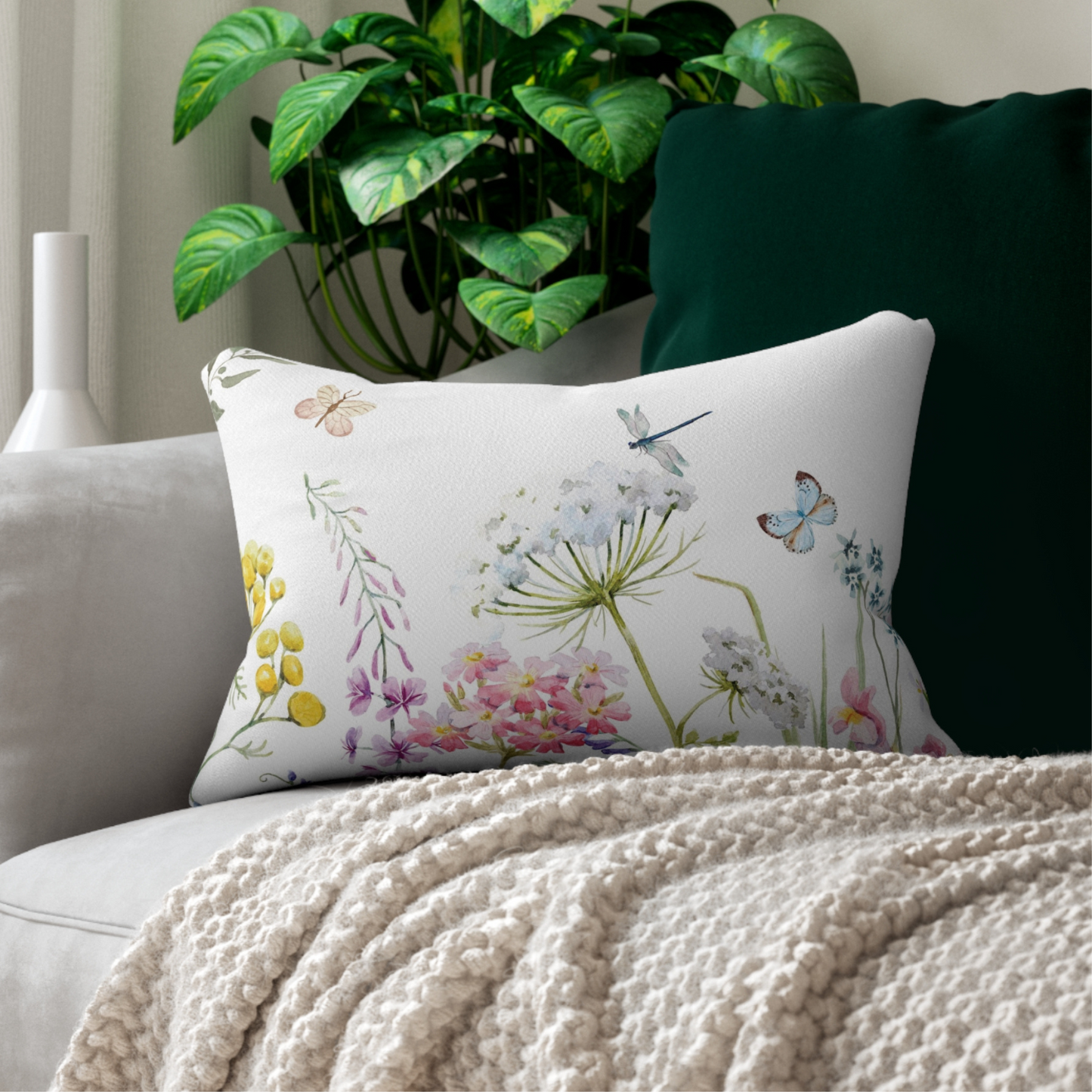 a white couch with a white blanket and a green plant