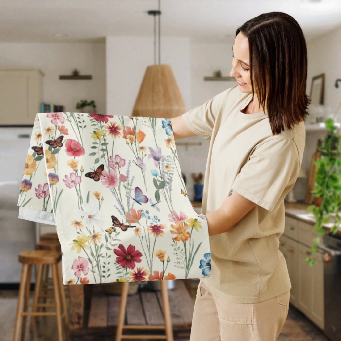 a woman holding a piece of table runner with flowers and butterflies on it