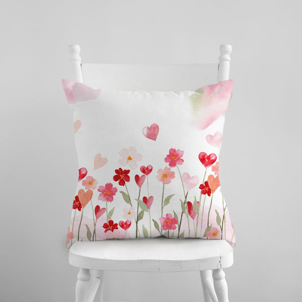 a white chair with a pink and red pillow on it