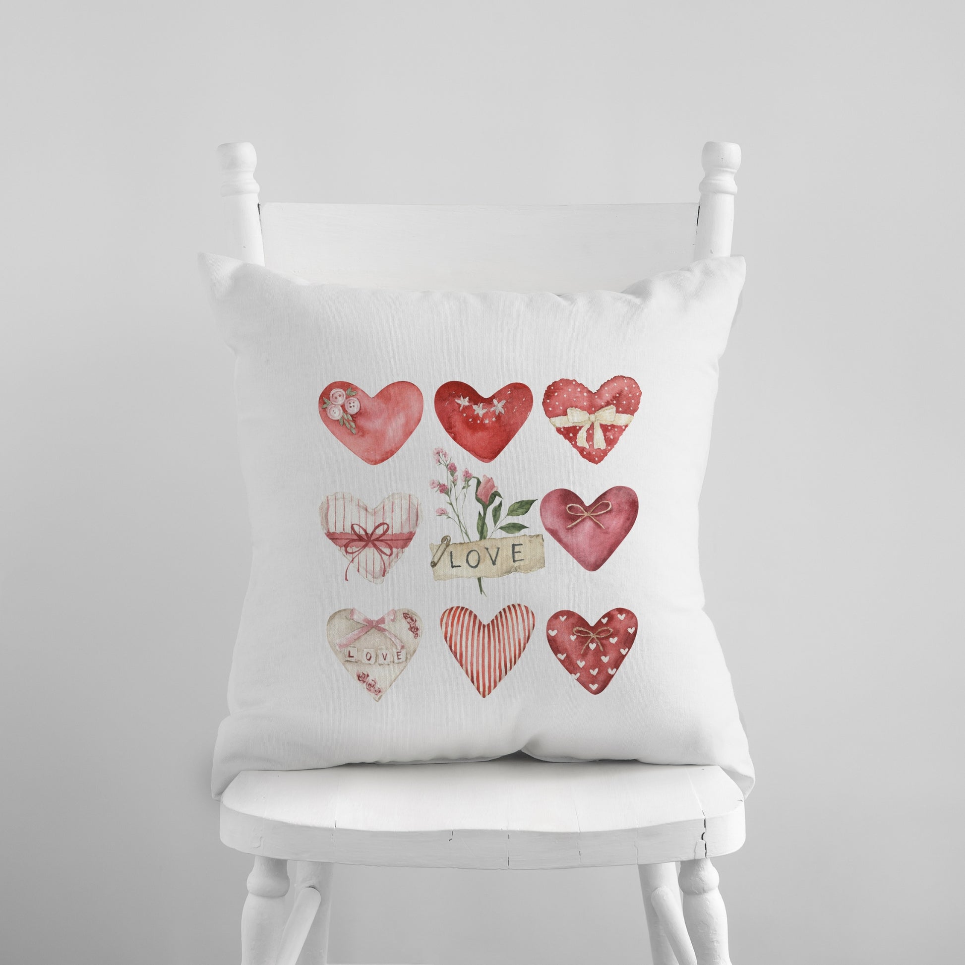 a white chair with a white pillow with a bunch of hearts on it