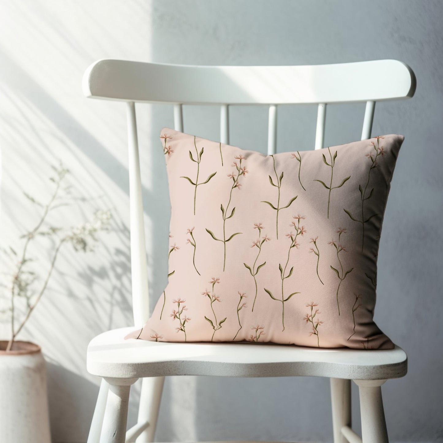 a white chair with a pink pillow on it