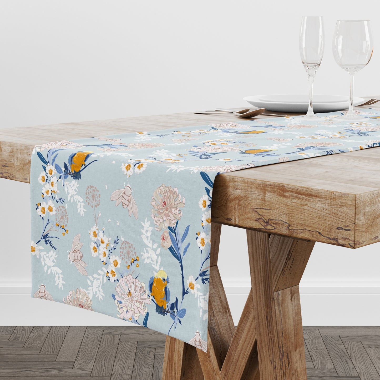 a table with a blue table cloth with flowers on it