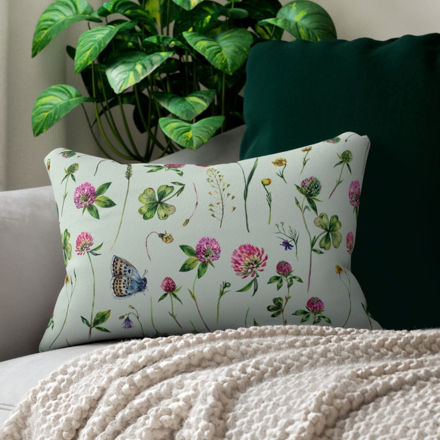 a white couch with a white blanket and a green plant