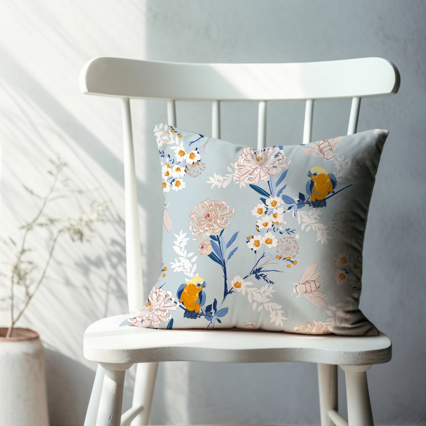 a white chair with a blue and yellow pillow on it