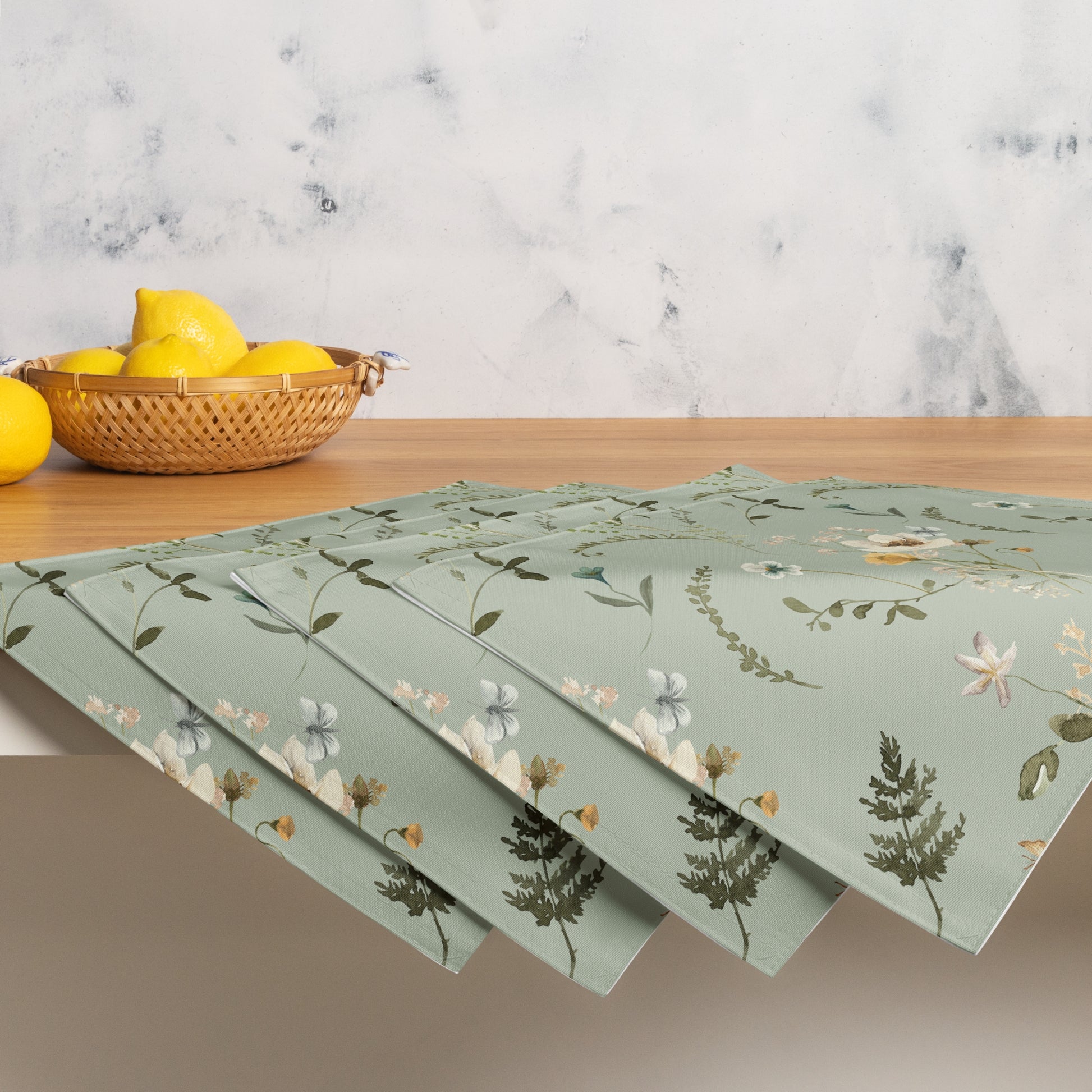 a basket of lemons and Green botanical placemat from Blue Water Songs sitting on top of a table