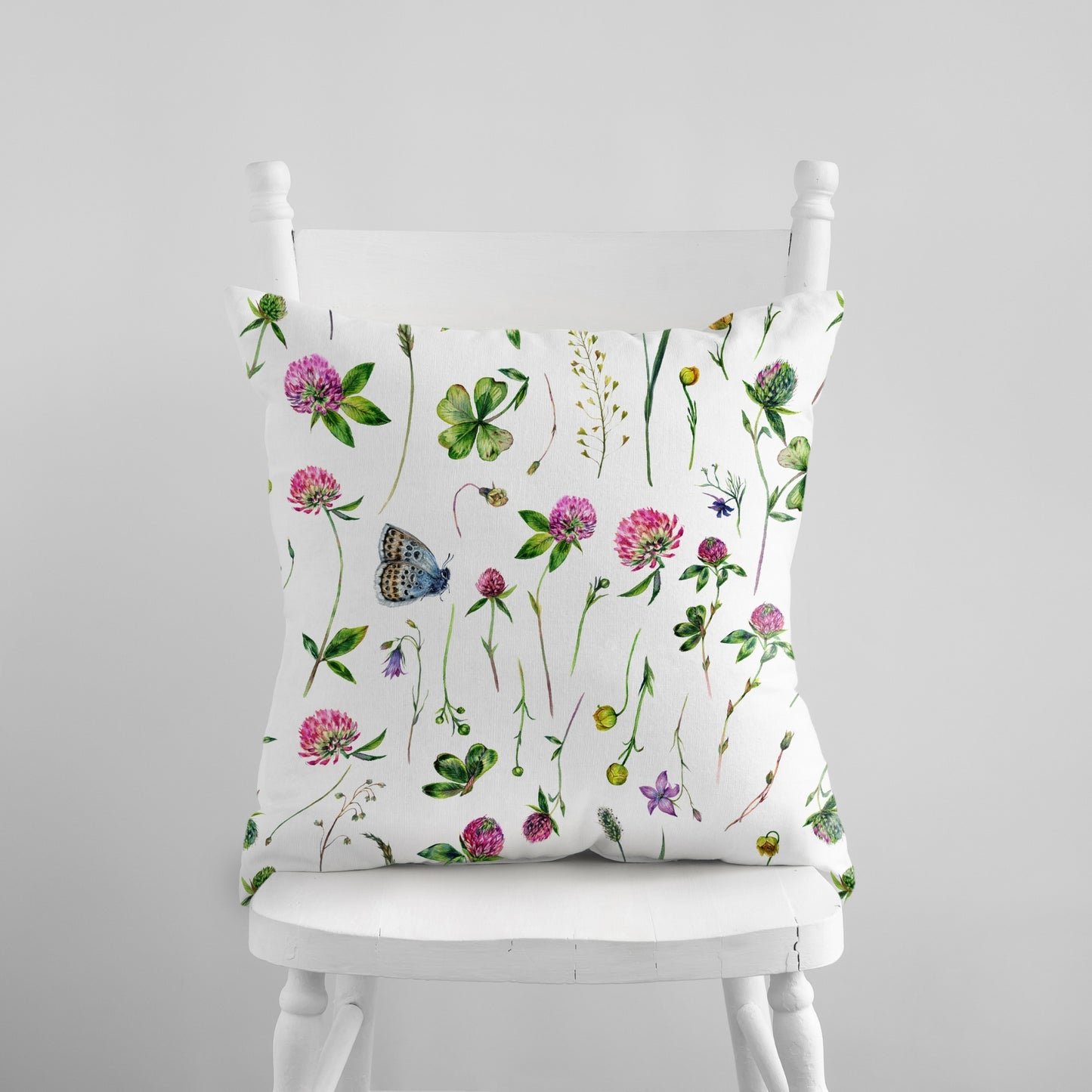 a white chair with a flowered pillow on it