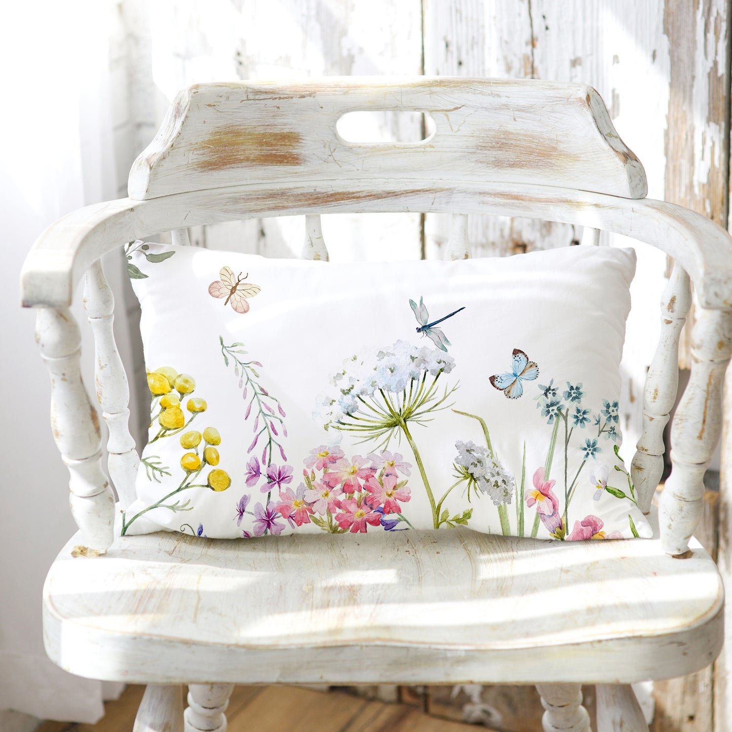 a white chair with a white pillow on top of it