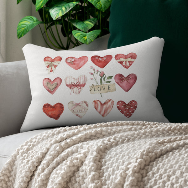 a white couch with a white blanket and a pillow with hearts on it