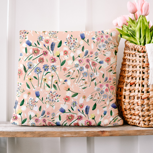 a pink floral pillow sitting on top of a wooden shelf