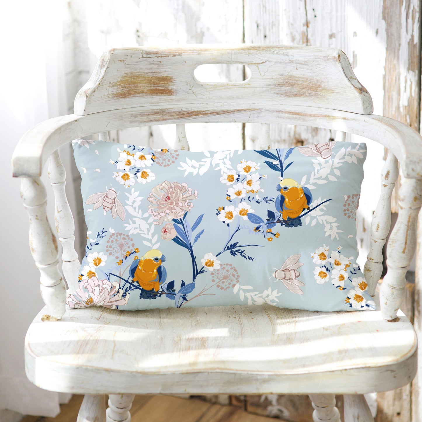 a white chair with a blue floral pillow on it