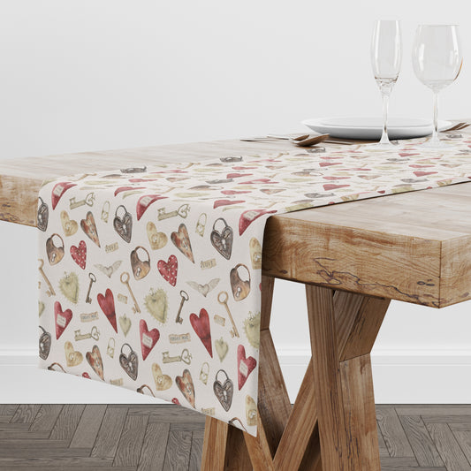 a table with a table cloth with hearts and keys on it