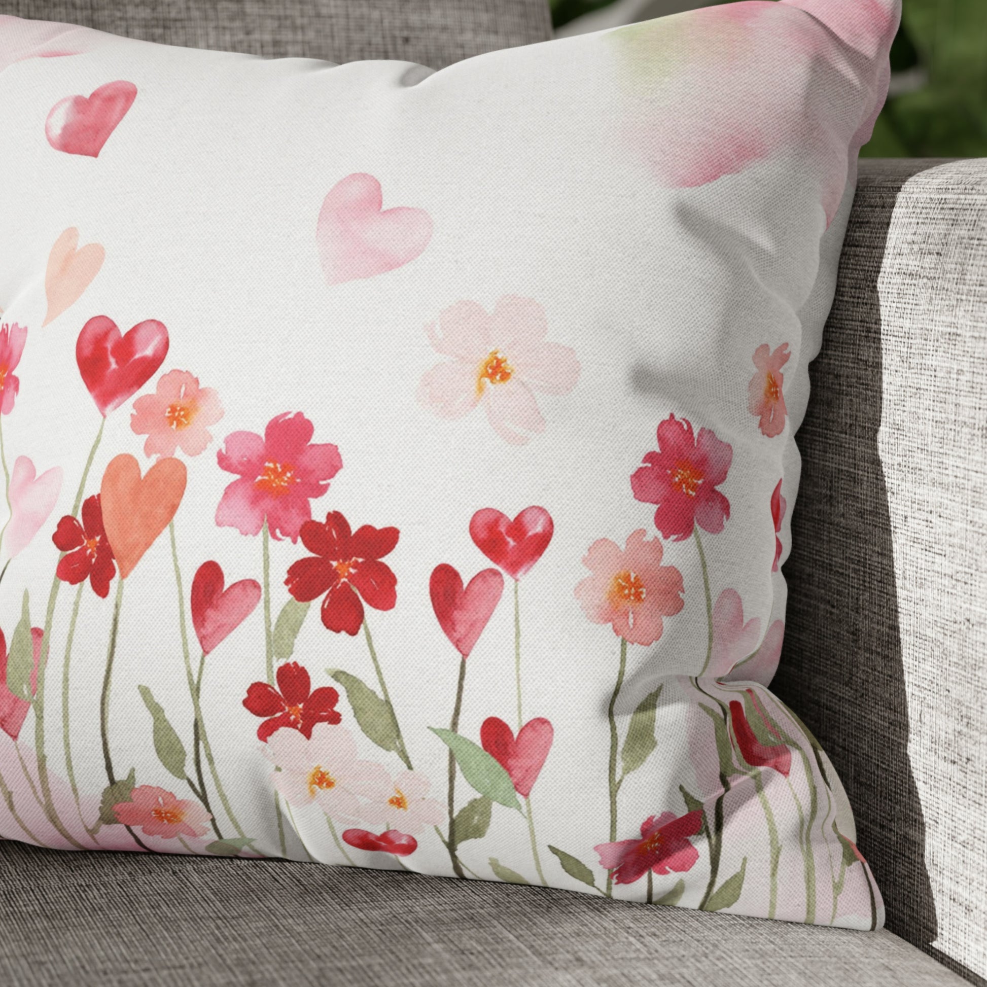 a white pillow with red and pink flowers on it