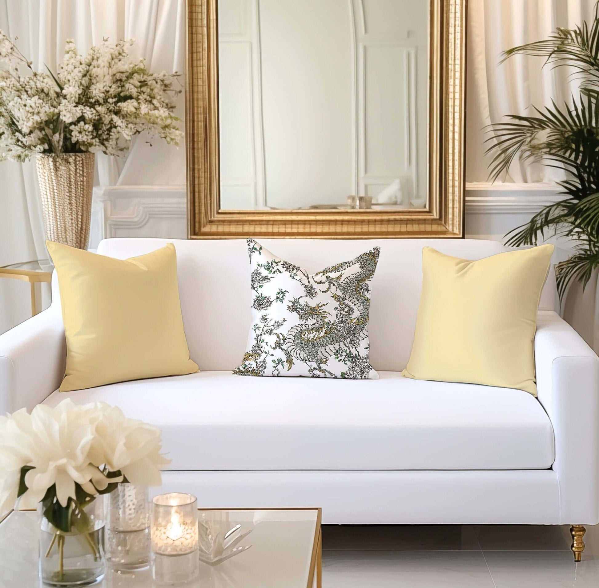 Chinoiserie dragon pillow on white sofa with yellow accent pillows. Oriental design in living room decor.