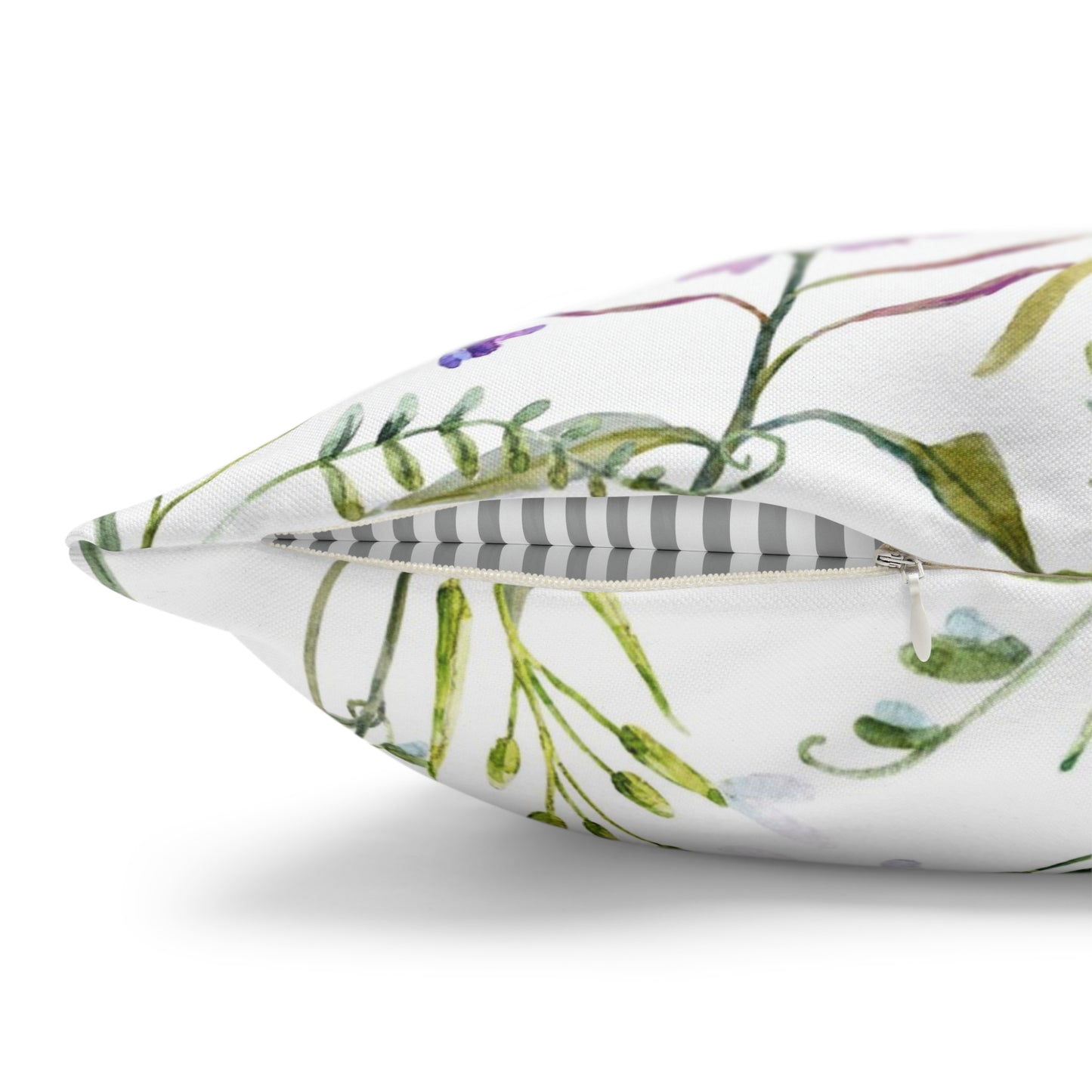 a white pillow with green and purple flowers on it