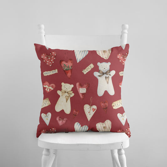 a white chair with a red pillow with teddy bears on it