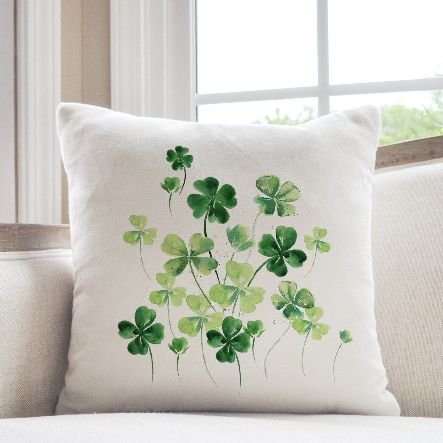 a white couch with a white pillow with green shamrocks on it