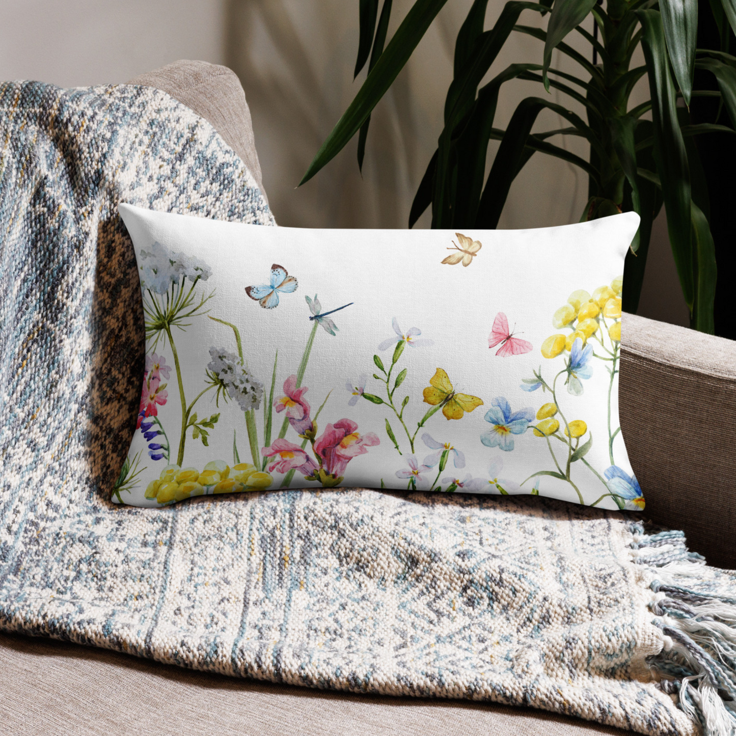 a pillow on a couch with flowers and butterflies on it