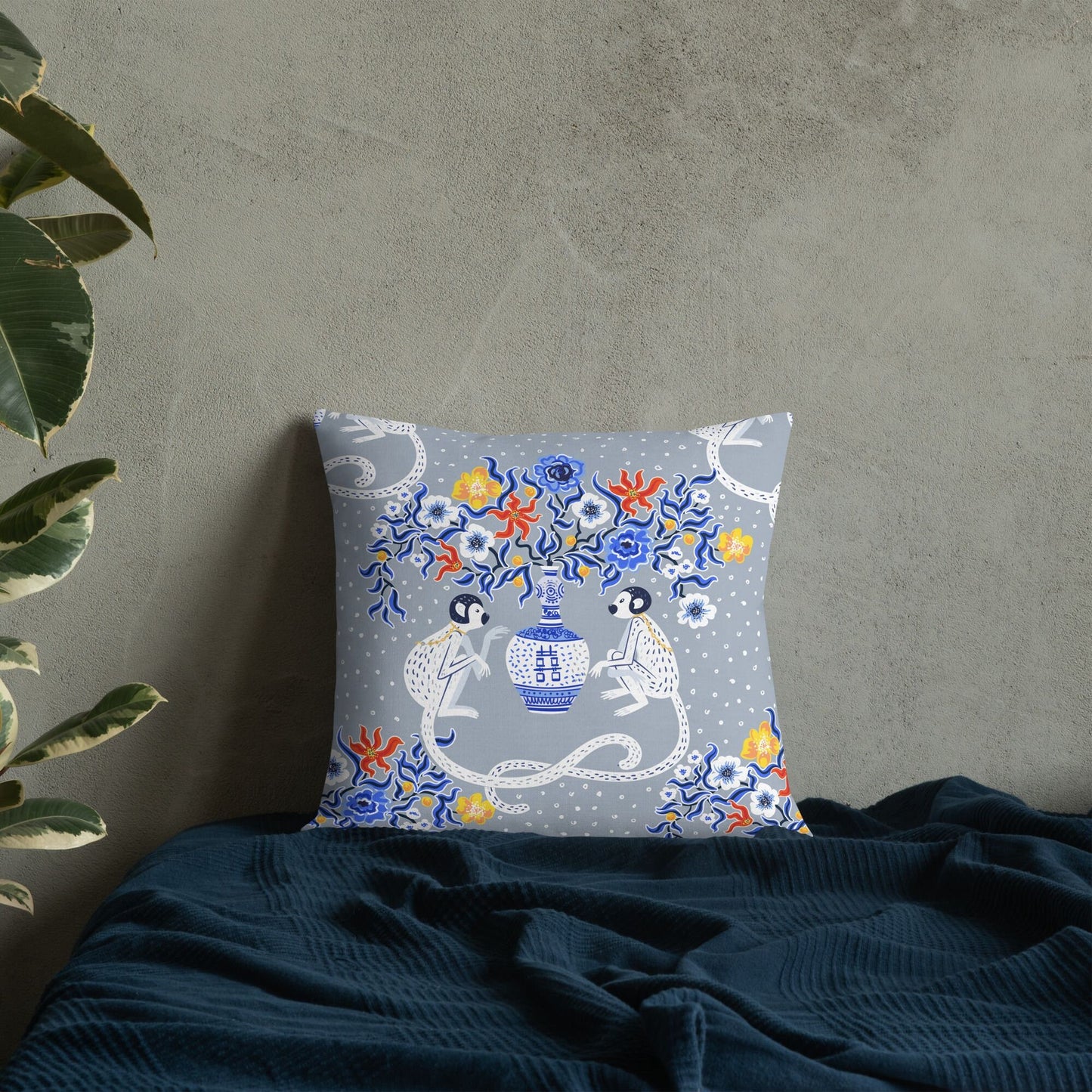 Chinoiserie monkey throw pillow on blue fabric. Oriental design with pagoda vase and floral accents.